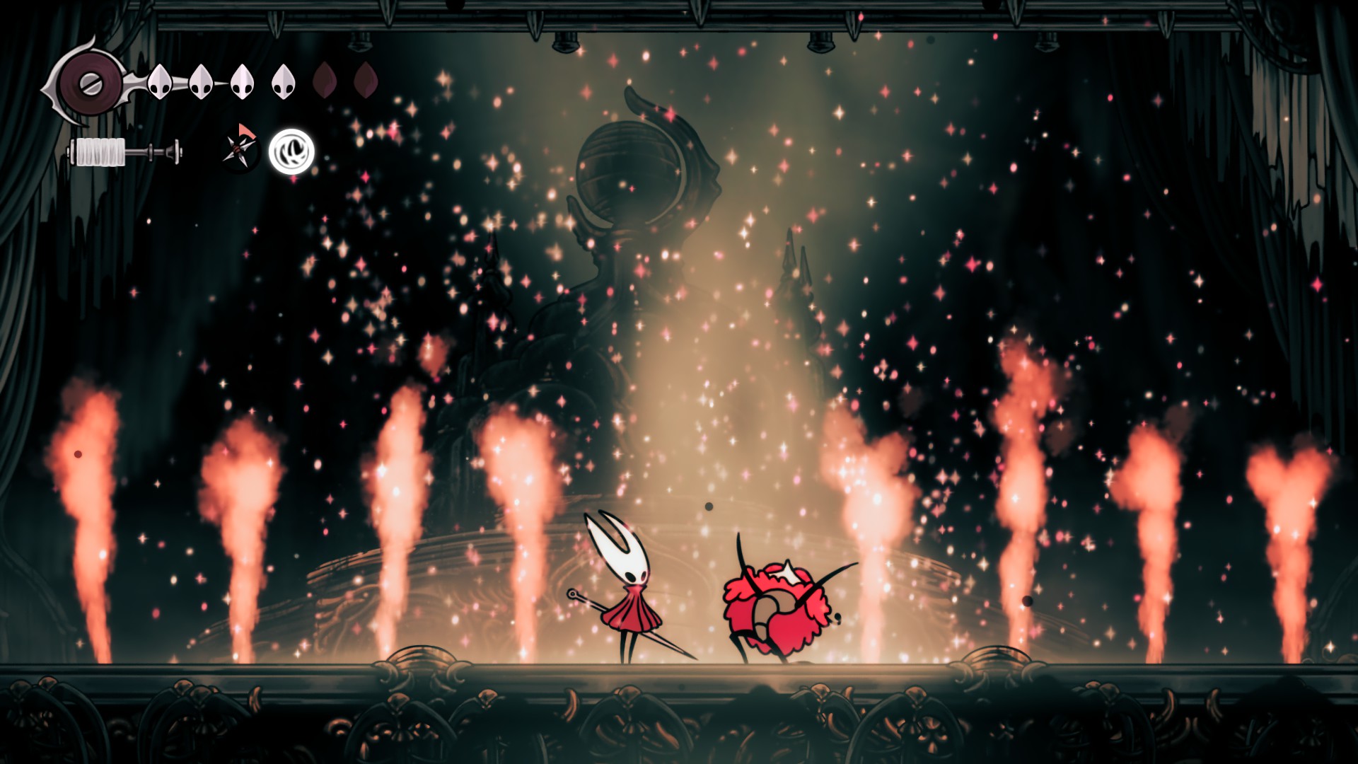 En un escenario, Hornet luchando contra un bicho fabuloso llevando una bufanda rosa que hace muchas explosiones rosas y se llama TTTTTTTTTTTTTTTTRRRRRRRRRRRRRRROOOOOOOOOOBBBBBBBIIIIIOOOOOO